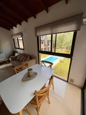 a white table and chairs in a living room at Departamento con pileta y asadores in Villa General Belgrano