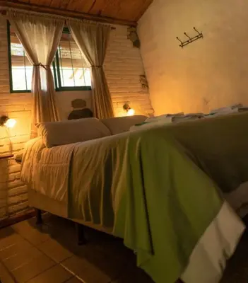 a bedroom with a large bed in a room at Cabañas Los Hornillos de Juli y Marce in Los Hornillos