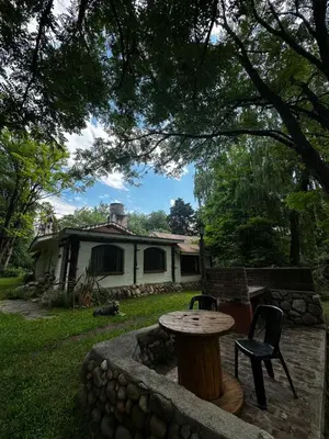 a table and chairs in front of a house at Cabañas Los Hornillos de Juli y Marce in Los Hornillos