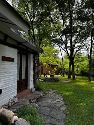 a house with a stone path next to a yard at Cabañas Los Hornillos de Juli y Marce in Los Hornillos