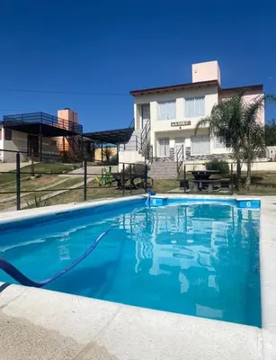 a large blue swimming pool in front of a building at Apart La Sole in Tanti