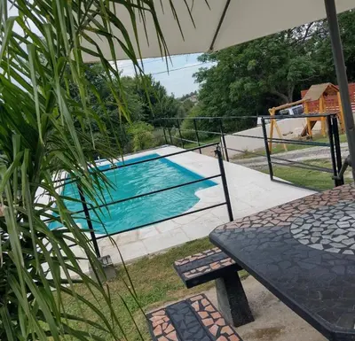 a swimming pool with a table and an umbrella at Apart La Sole in Tanti