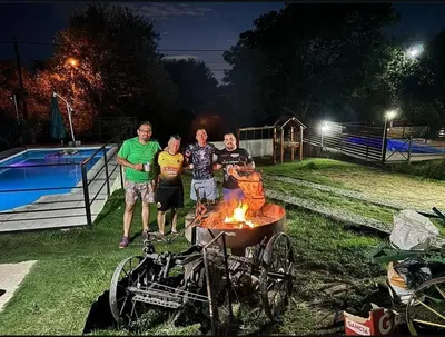 a group of people standing around a fire pit at Apart La Sole in Tanti