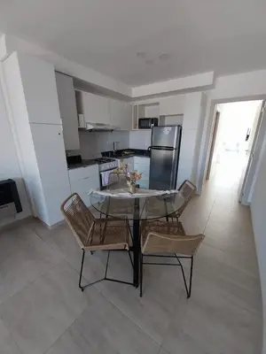a kitchen with a table and chairs in a room at Prado del Lago in Villa Rumipal