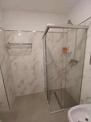 a shower with a glass door next to a sink at Prado del Lago in Villa Rumipal