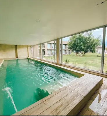 a swimming pool in a house with a large window at Prado del Lago in Villa Rumipal