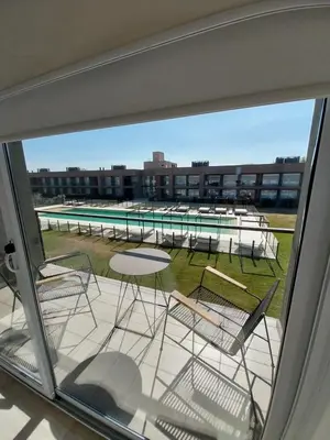 a balcony with chairs and tables and a swimming pool at Prado del Lago in Villa Rumipal