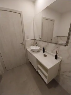 a white bathroom with a sink and a mirror at Prado del Lago in Villa Rumipal