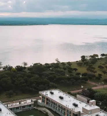an aerial view of a building next to a body of water at Prado del Lago in Villa Rumipal