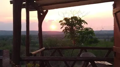 a view of the sunset from the porch of a house at La lomita de Nono in Arroyo de Los Patos
