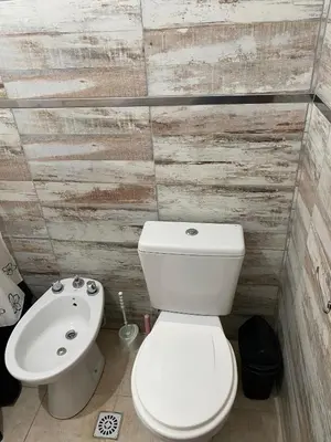 a bathroom with a white toilet and a sink at La lomita de Nono in Arroyo de Los Patos