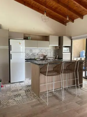 a kitchen with a refrigerator and a counter with stools at Casareartesesok in Los Reartes