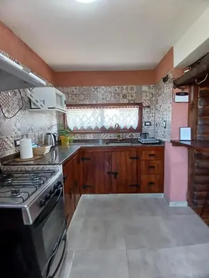 a kitchen with wooden cabinets and a stove top oven at La Casa de Conco in La Estancia