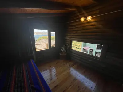 an empty room with two windows in a log cabin at La Casa de Conco in La Estancia