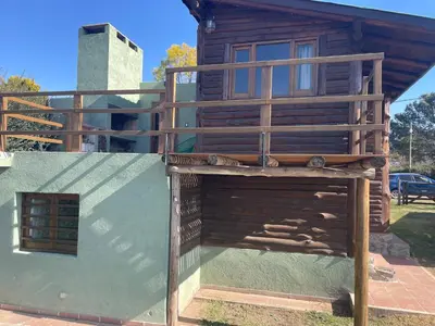 a wooden house with a balcony on the side of it at La Casa de Conco in La Estancia