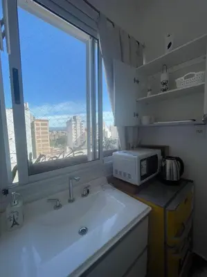 a kitchen with a sink and a window and a microwave at Pequeño y acogedor depto sin cocina, tiene freidora de aire y microondas in Cordoba
