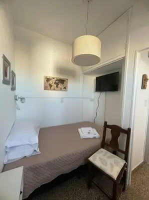 a bedroom with a bed and a chair and a lamp at Pequeño y acogedor depto sin cocina, tiene freidora de aire y microondas in Cordoba