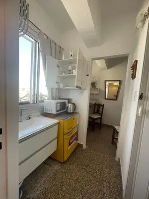 a small kitchen with a sink and a microwave at Pequeño y acogedor depto sin cocina, tiene freidora de aire y microondas in Cordoba
