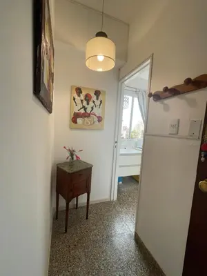 a hallway with a door and a table and a refrigerator at Pequeño y acogedor depto sin cocina, tiene freidora de aire y microondas in Cordoba