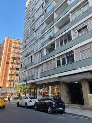 two cars parked in front of a tall building at Pequeño y acogedor depto sin cocina, tiene freidora de aire y microondas in Cordoba