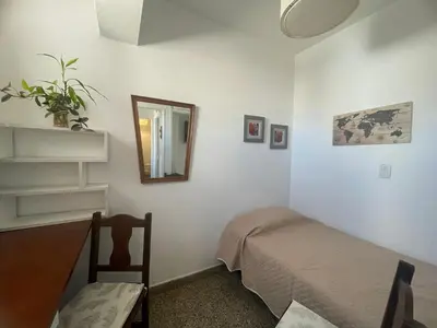 a bedroom with a bed and a mirror and a chair at Pequeño y acogedor depto sin cocina, tiene freidora de aire y microondas in Cordoba