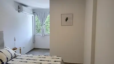 a white room with a bed and a window at Agradable departamento en Alta Córdoba in Cordoba