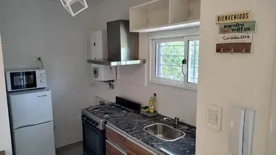 a small kitchen with a sink and a refrigerator at Agradable departamento en Alta Córdoba in Cordoba