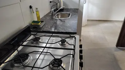 a stove top oven in a kitchen next to a sink at Agradable departamento en Alta Córdoba in Cordoba