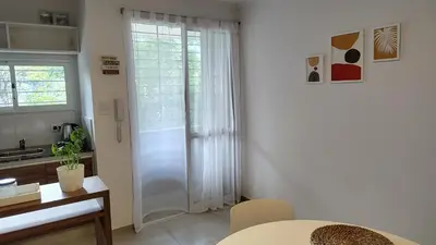 a kitchen with a white door and a table at Agradable departamento en Alta Córdoba in Cordoba