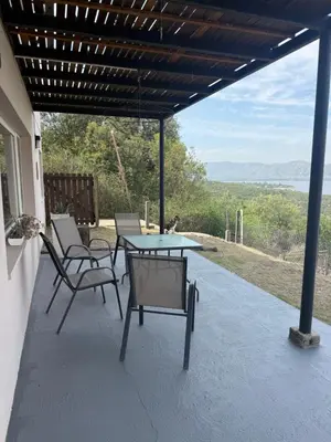a patio with chairs and a table with a view at Departamento Paris in Villa Carlos Paz