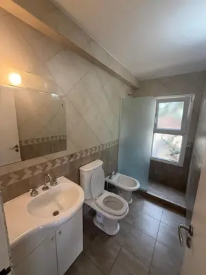a bathroom with a sink and a toilet and a mirror at Departamento Paris in Villa Carlos Paz