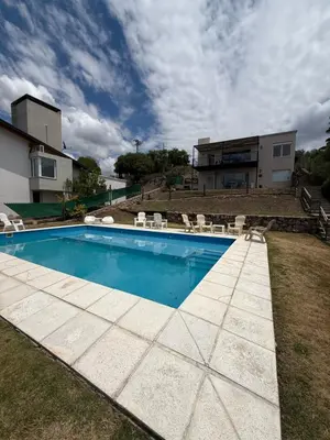 a swimming pool in the yard of a house at Departamento Paris in Villa Carlos Paz