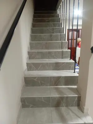 a staircase with gray stone steps with a person walking down them at Departamento calido, cerc in Río Tercero