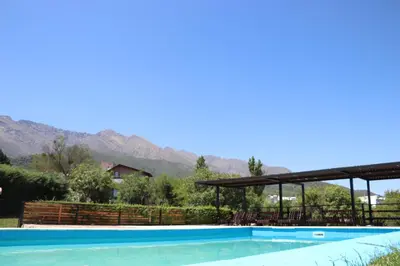 a swimming pool with mountains in the background at Kentitaku cabañas de montaña in Las Rabonas