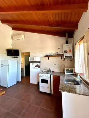 a kitchen with a white refrigerator and a sink at Kentitaku cabañas de montaña in Las Rabonas