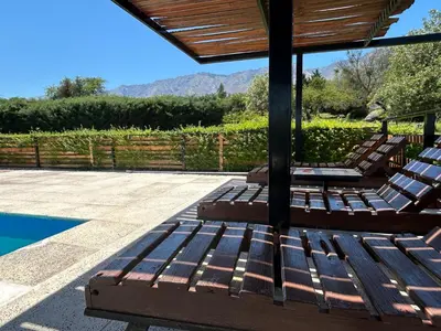 a group of chairs sitting next to a swimming pool at Kentitaku cabañas de montaña in Las Rabonas