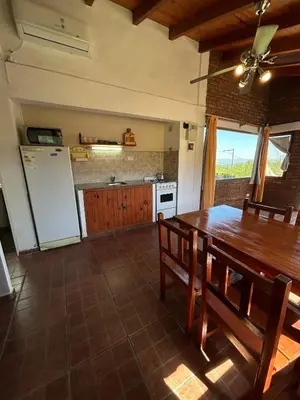 a kitchen with a wooden table and a refrigerator at Kentitaku cabañas de montaña in Las Rabonas