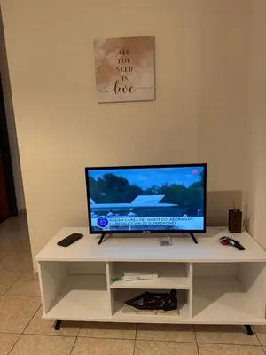 a flat screen tv sitting on top of a white cabinet at Precioso y Muy Cómodo Departamento en Excelente Zona Centrica in Cordoba