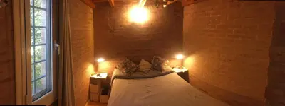 a bed in a room with a brick wall at Balcones de Costa Azul in Villa Carlos Paz