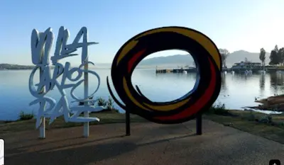 a large mirror in front of a body of water at Balcones de Costa Azul in Villa Carlos Paz