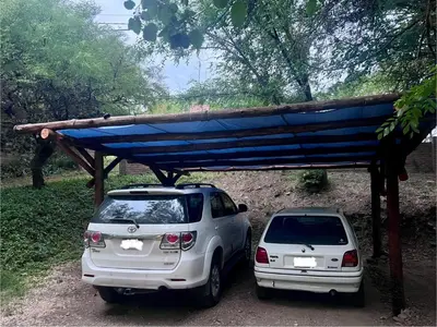 two cars parked next to each other under a blue covering at Balcones de Costa Azul in Villa Carlos Paz