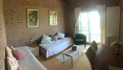 a living room with a bed and a brick wall at Balcones de Costa Azul in Villa Carlos Paz