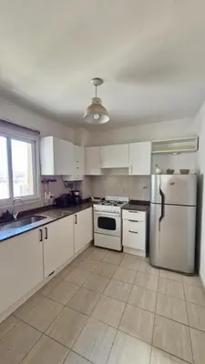 a kitchen with white cabinets and a refrigerator at Bravo 6 - Luminoso y amplio depto cerca de todo! in Cordoba