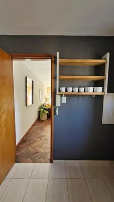 a room with a blue wall with a shelf on the wall at Bravo 6 - Luminoso y amplio depto cerca de todo! in Cordoba
