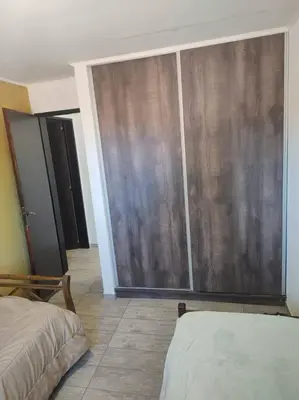 a bedroom with a sliding glass door and a bed at Casa en las sierras de Córdoba con Deck , Parrilla y estacionamiento in Cavalango