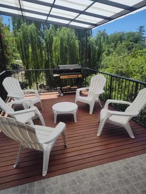 a deck with white rocking chairs and a piano at Casa en las sierras de Córdoba con Deck , Parrilla y estacionamiento in Cavalango