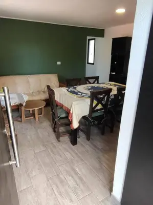 a living room with a couch and a table and chairs at Casa en las sierras de Córdoba con Deck , Parrilla y estacionamiento in Cavalango