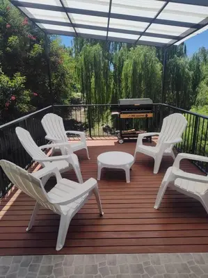 a deck with chairs and a table and a grill at Casa en las sierras de Córdoba con Deck , Parrilla y estacionamiento in Cavalango