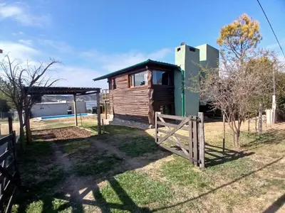 a wooden cabin with a gate and a fence at La Casa de Conco in La Estancia