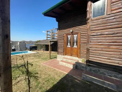 a wooden house with a door and a yard at La Casa de Conco in La Estancia